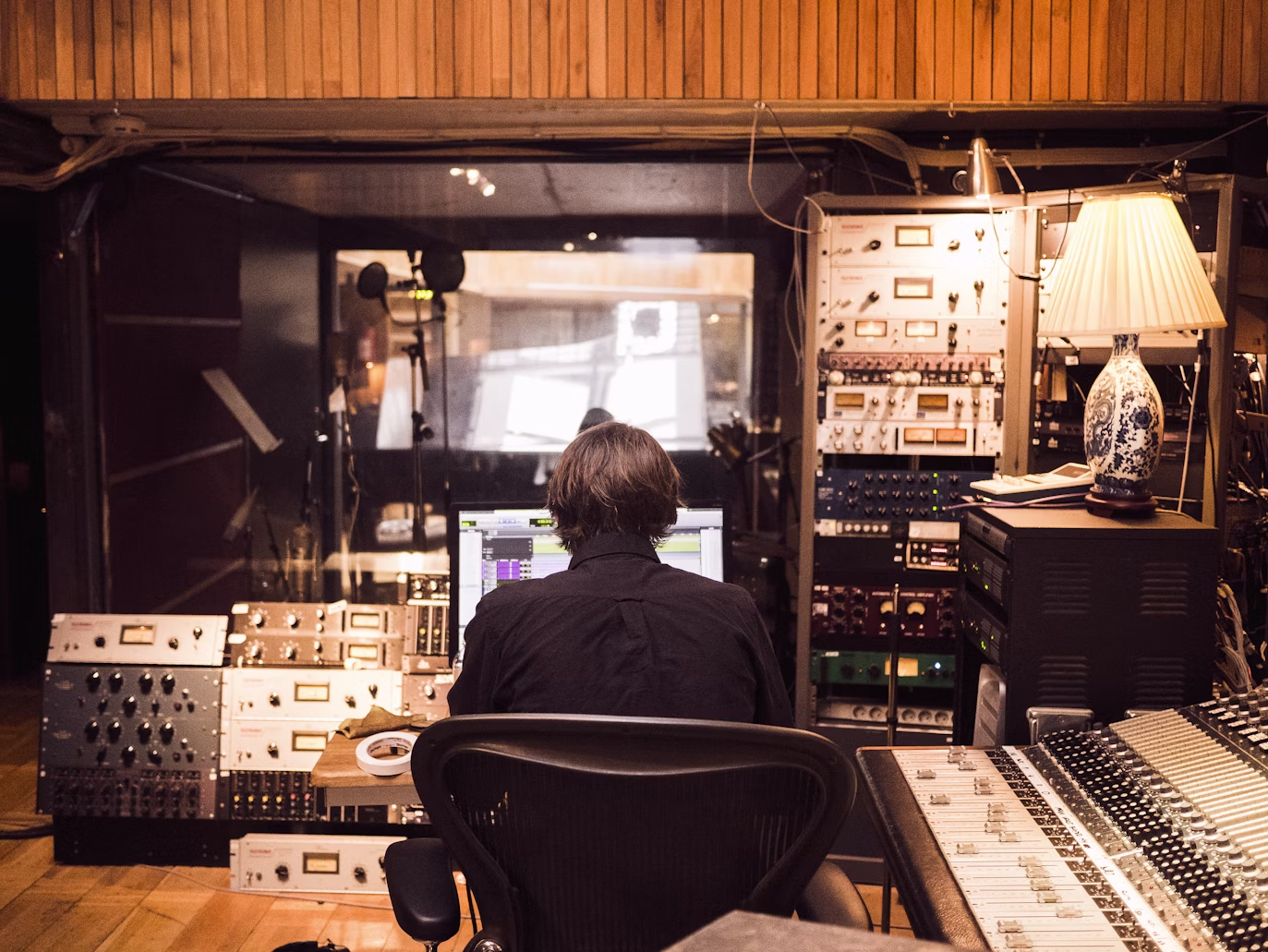 Hombre delante del mezclador en el estudio.
