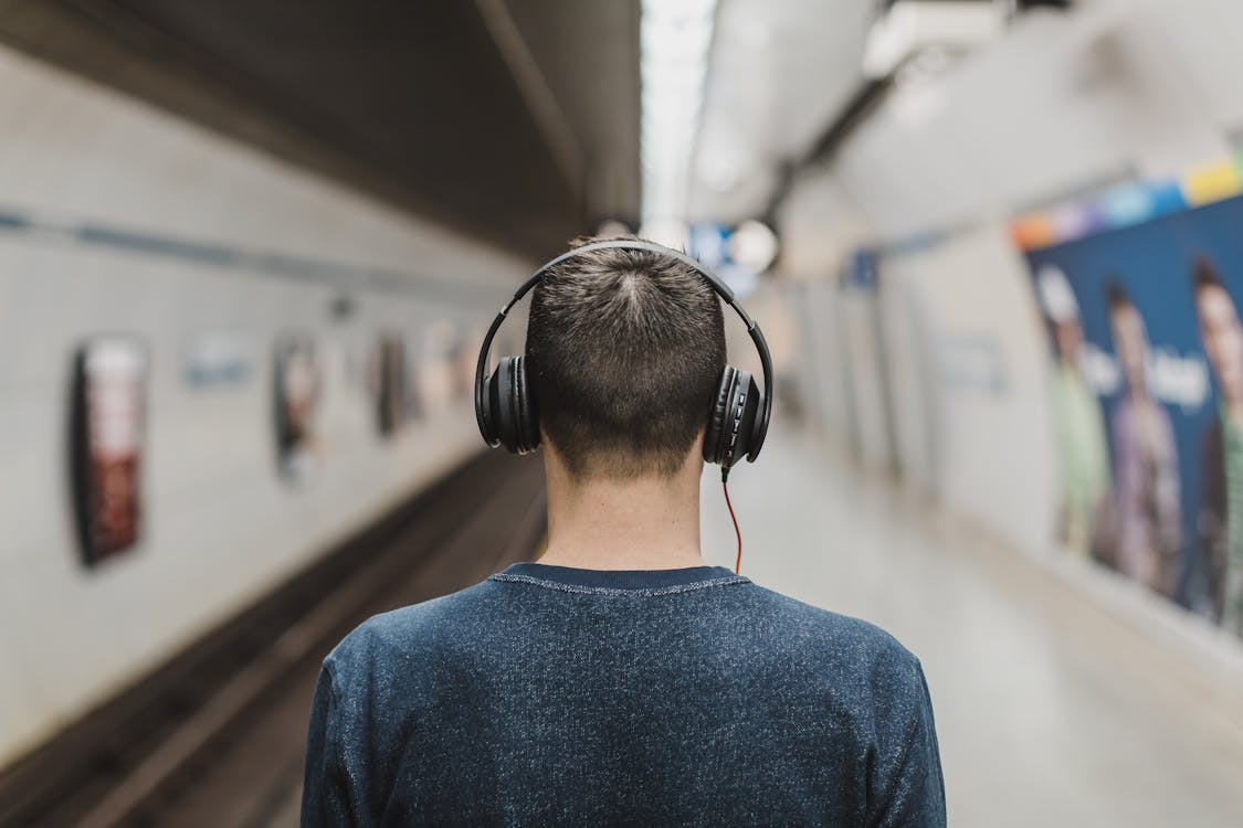 Un hombre escucha música con auriculares en el metro