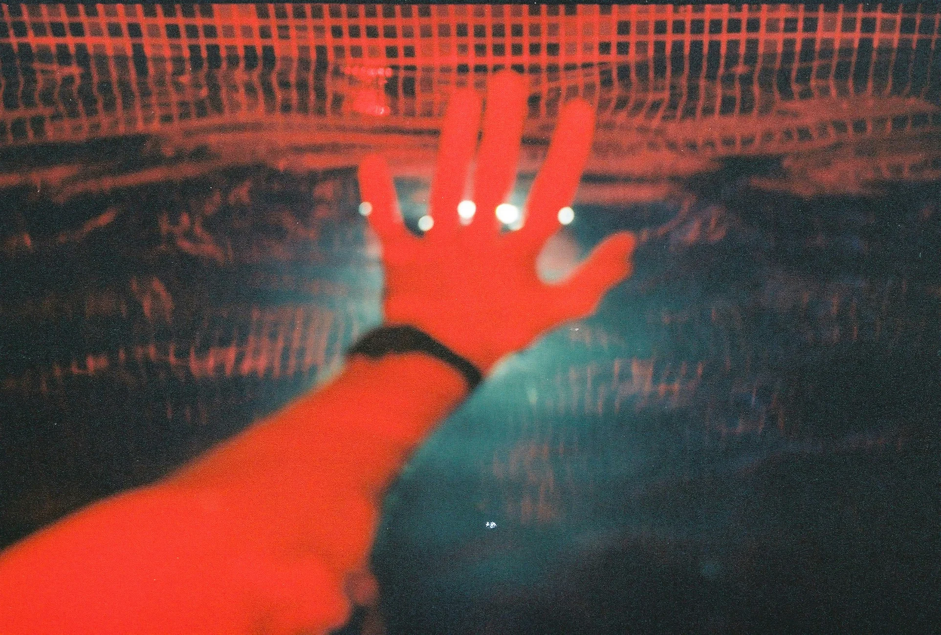 Una mano extendida bajo luz roja.