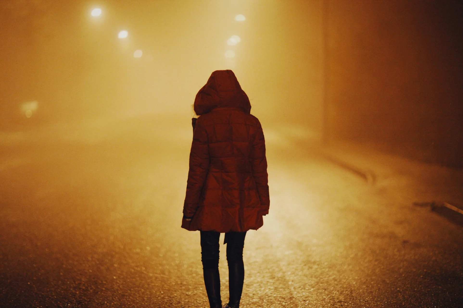 Una joven camina en la niebla.