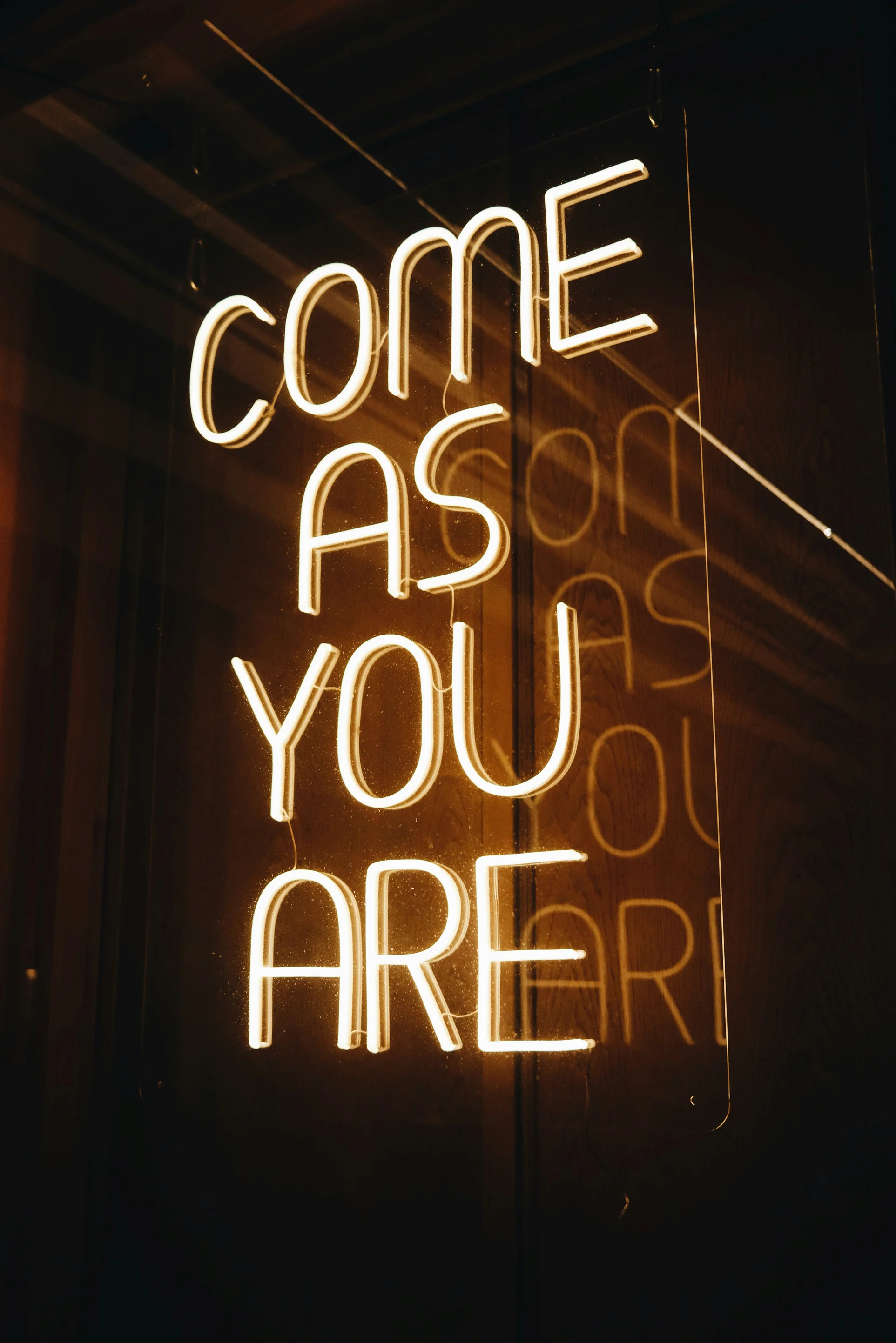 Cartel de neón con la leyenda 'Come As You Are'.
