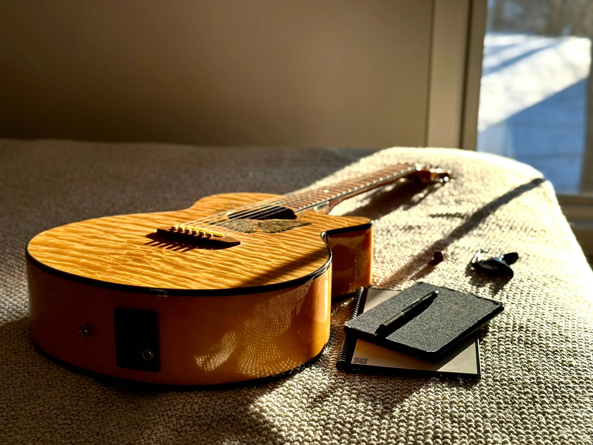 Una guitarra y un bloc de notas.