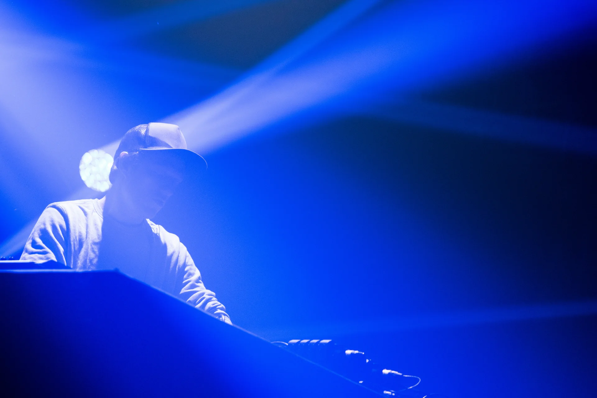 Músico actuando bañado en luz azul.